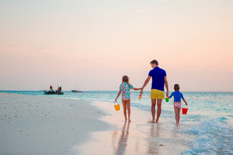 快乐父亲和他的孩子们热带海滩日落快乐父亲和他的可爱的小女儿热带海滩有有趣的