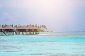 热带海滩马尔代夫与水翼蓝色的环礁湖马尔代夫天堂海滩美丽的海滩与棕榈树和喜怒无常的天空夏天假期旅行假期背景概念马尔代夫天堂海滩