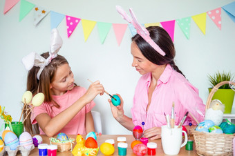 快乐复活节妈妈与她的女儿绘画复活节鸡蛋可爱的小孩子们穿兔子耳朵复活节一天快乐复活节美丽的小孩子们穿兔子耳朵复活节一天