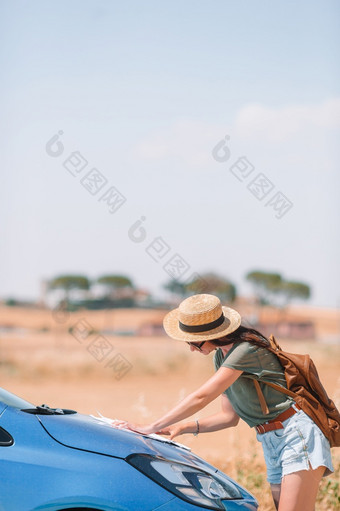 年轻的女人看为的正确的<strong>道路</strong>在<strong>旅行</strong>车旅游女孩托斯卡纳假期女人为新冒险看为的正确的<strong>道路</strong>的地图