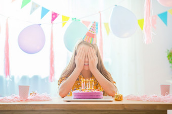 快乐小女孩使希望她的生日生日聚会，派对和祝愿概念高加索人女孩如痴如梦微笑和看生日彩虹蛋糕节日<strong>色彩斑斓</strong>的背景与气球生日聚会，派对和祝愿概念