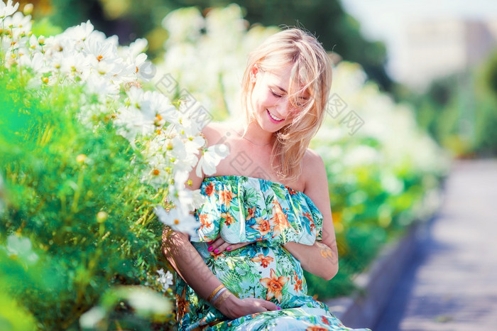 怀孕了女人持有肚子在阳光明媚的夏天背景的公园在户外怀孕了女人户外公园温暖的天气