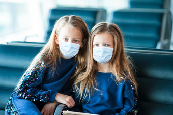 孩子们与外科手术面具脸保护国际机场会登机在一起小孩子机场等待为登机