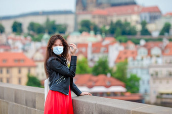 快乐年轻的女人穿面具为防止病毒欧洲城市的著名的桥布拉格捷克共和国高加索人旅游走沿着的空街道欧洲快乐年轻的城市女人欧洲城市的著名的桥布拉格捷克共和国高加索人旅游走沿着的空街道欧洲