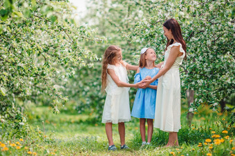 可爱的小女孩与年轻的妈妈。盛开的花园美丽的春天一天可爱的小女孩与年轻的妈妈。盛开的樱桃花园美丽的春天一天