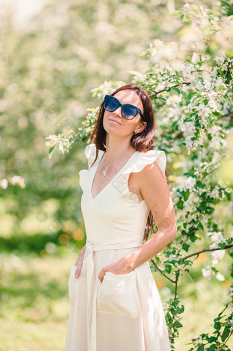 美丽的女人白色衣服享受气味春天樱桃花园美丽的女人享受气味春天樱桃花园