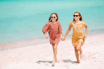 小女孩有有趣的热带海滩在夏天假期小快乐有趣的女孩有很多有趣的热带海滩玩在一起