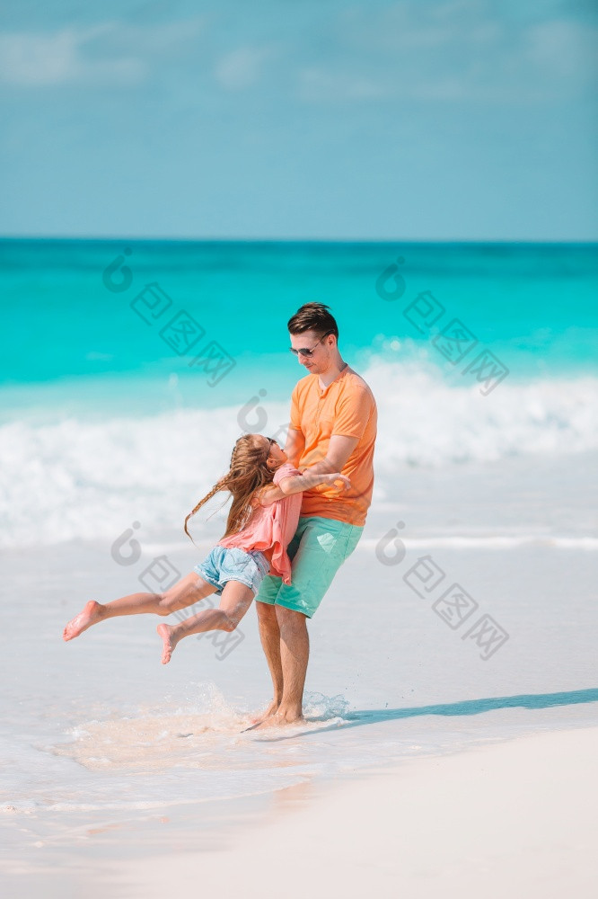 快乐父亲和他的可爱的小女儿热带海滩快乐父亲和他的可爱的小女儿热带海滩走在一起