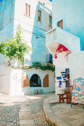 意大利佩斯基奇6月的狭窄的街道与楼梯白色房子和花美丽的村意大利美丽的体系结构建筑外佩斯基奇历史中心的狭窄的街道的岛与蓝色的阳台楼梯和花