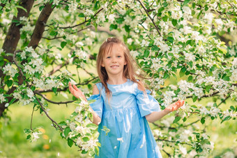 肖像<strong>美丽</strong>的小女孩盛开的苹果树<strong>花园</strong>春天一天可爱的小女孩盛开的苹果<strong>花园美丽</strong>的春天一天