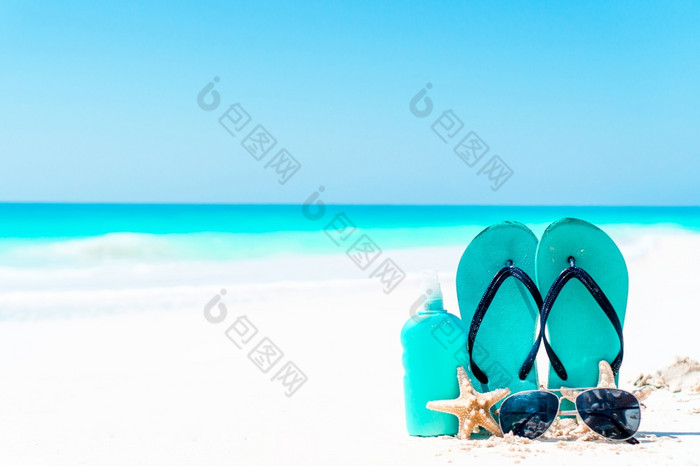 翻转失败防晒霜瓶护目镜海星和太阳镜白色沙子海滩背景海洋防晒霜瓶护目镜海星和太阳镜白色沙子海滩背景海洋