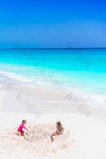 小女孩有有趣的热带海滩玩在<strong>一起</strong>和使沙塔两个小快乐女孩有很多有趣的热带海滩玩在<strong>一起</strong>