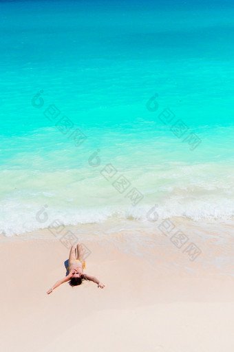 年轻的女人享受的太阳日光浴<strong>完美</strong>的绿松石海洋白色海滩年轻的女人享受的太阳日光浴<strong>完美</strong>的绿松石海洋