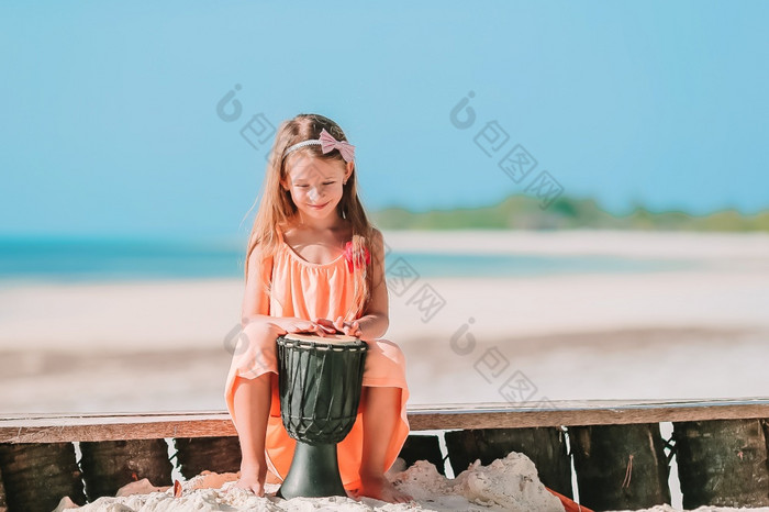 小快乐女孩玩非洲鼓可爱的孩子有有趣的与国家非洲鼓白色海滩小快乐女孩玩非洲鼓