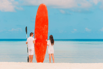 夫妇与<strong>冲浪板</strong>的海滩年轻的夫妇与红色的<strong>冲浪板</strong>在热带假期