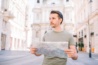 男人。旅游与城市地图街道老欧洲城市男人。旅游与城市地图和背包欧洲街高加索人男孩看与地图欧洲城市