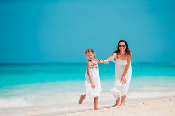 年轻的美丽的妈妈。和她的可爱的小女儿热带海滩美丽的妈妈。和女儿加勒比海滩