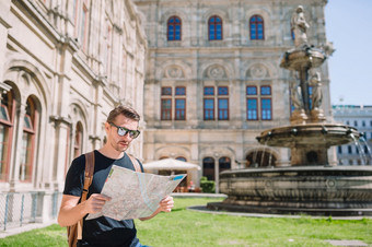 男人。旅游与城市地图维也纳背景著名的维也纳歌剧房子男人。旅游与城市地图和背包欧洲街高加索人男孩看与地图欧洲城市
