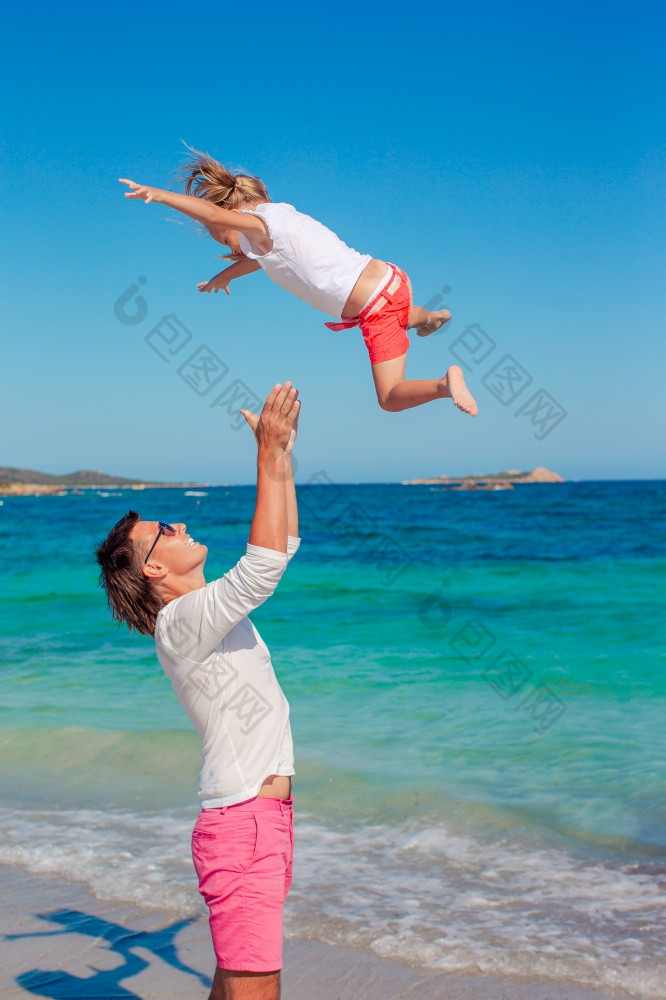 快乐父亲和他的可爱的小女儿白色桑迪海滩有有趣的小女孩和快乐爸爸有有趣的在海滩假期