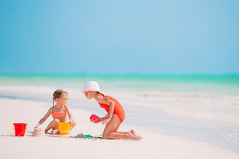 可爱的小女孩玩与玩具海滩假期可爱的小女孩玩与海滩玩具白色tropial海滩
