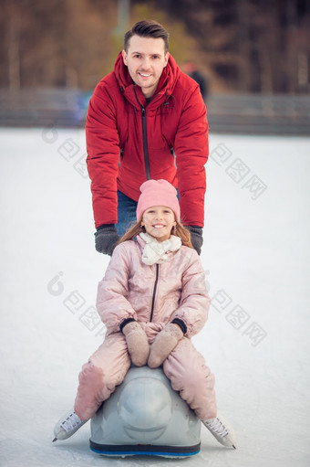 家庭冬天体育运动家庭滑冰的溜冰场家庭冬天体育运动父亲和女儿冬天一天