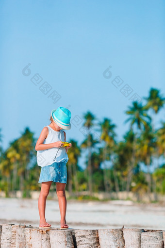 活跃的小女孩白色海滩有有趣的特写镜头孩子背景的嚎叫树活跃的小女孩白色海滩有有趣的