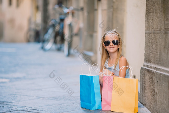 肖像可爱的小女孩与购物袋在户外欧洲城市时尚蹒跚学步的孩子意大利城市与她的购物肖像可爱的小女孩走与购物袋在户外欧洲城市