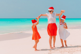 家庭妈妈。和孩子们<strong>圣诞老人</strong>他新一年假期的海滩快乐美丽的家庭红色的<strong>圣诞老人帽子</strong>热带海滩庆祝圣诞节