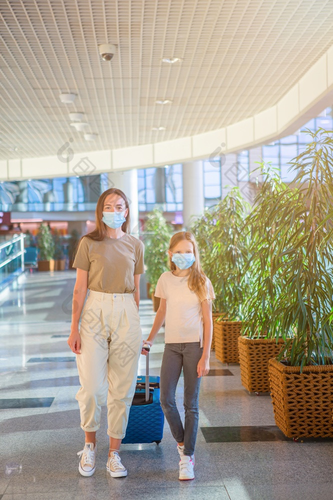 家庭脸面具机场妈妈。和孩子穿口罩在冠状病毒和流感爆发保护对冠状病毒和抓手妈妈。和小女孩与内迪卡尔面具机场保护对冠状病毒和抓手