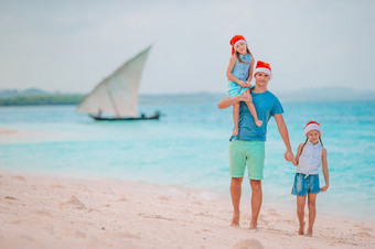 快乐家庭父亲和孩子们<strong>圣诞老人</strong>他夏天假期快乐家庭红色的<strong>圣诞老人帽子</strong>热带海滩庆祝圣诞节假期