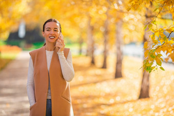 快乐女人与马林秋天公园下秋天树叶金秋天公园秋天概念美丽的女人秋天公园下秋天树叶