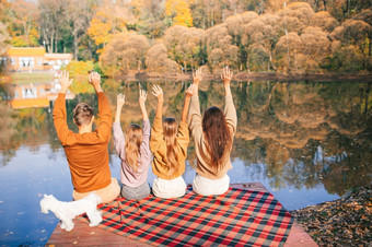 快乐家庭<strong>四个</strong>享受秋天一天的湖美丽的家庭秋天温暖的一天附近湖