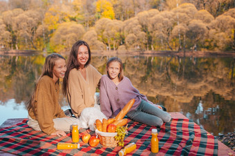 家庭一天妈妈。和她的小女孩秋天野餐的湖快乐家庭野餐的公园秋天
