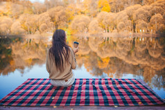 美丽的女孩秋天公园享受的视图的湖秋天概念美丽的女人喝咖啡秋天公园