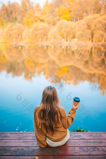 可爱的女孩与热外卖咖啡在户外秋天一天附近湖可爱的小女孩美丽的秋天一天在户外