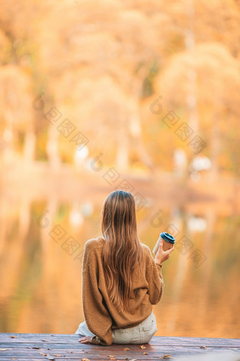 可爱的女孩秋天公园的湖享受的视图秋天概念美丽的女孩秋天公园的湖