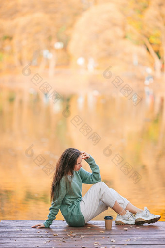 可爱的女人秋天公园的湖享受的视图秋天概念美丽的女孩秋天公园的湖