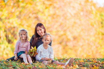 年轻的妈妈。与可爱的小女孩秋天公园阳光明媚的一天家庭享受温暖的天气9月一天小女孩与妈妈在户外公园秋天一天