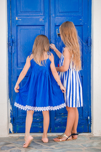 小快乐女孩礼服街典型的希腊传统的村与白色墙和色彩斑斓的门米克诺斯岛希腊小快乐女孩礼服街典型的希腊传统的村米克诺斯岛希腊