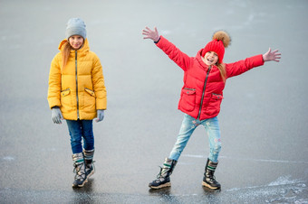 可爱的小女孩滑冰户外溜冰场和有有趣的在一起可爱的小女孩滑冰的溜冰场