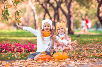 小可爱的女孩与南瓜在户外温暖的秋天一天肖像孩子们秋天10月小可爱的女孩与南瓜在户外温暖的秋天一天