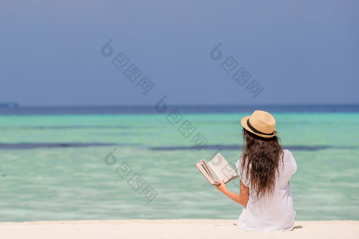 年轻的人阅读书在热带白色海滩肖像年轻的女人放松的海滩阅读书