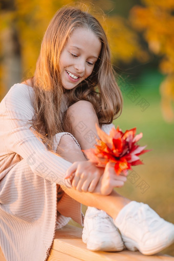 肖像可爱的小女孩与红色的花束秋天叶子秋天秋天公园肖像可爱的小女孩与黄色的叶子花束秋天