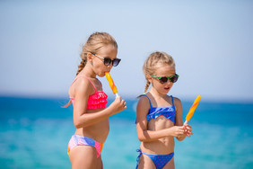 快乐小女孩吃冰淇淋在海滩假期人孩子们朋友和友谊快乐小女孩吃冰淇淋在海滩假期