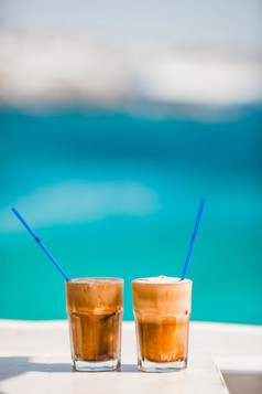 冰 沙冰咖啡的海滩夏天冰咖啡frappuccino冰 沙拿铁高玻璃背景的海海滩酒吧咖啡拿铁木表格与海背景
