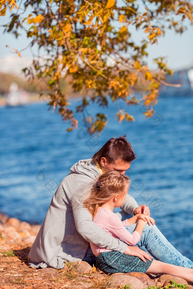 家庭秋天周末年轻的父亲和他的小女儿在一起秋天公园家庭爸爸和孩子美丽的秋天一天的公园