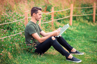 快乐年轻的城市男人。读书在户外zaryadye公园俄罗斯快乐年轻的城市男人。与书在户外
