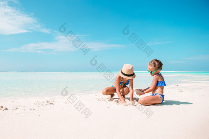 小女孩有有趣的热带海滩玩在一起可爱的小姐妹海滩在夏天假期两个小快乐女孩有很多有趣的热带海滩玩在一起