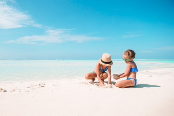 小女孩有有趣的热带海滩玩在一起可爱的小姐妹海滩在夏天假期两个小快乐女孩有很多有趣的热带海滩玩在一起