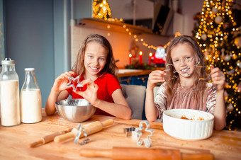 孩子们烤姜饼干圣诞节快乐孩子们庆祝假期装饰生活房间小女孩使圣诞节姜饼房子壁炉装饰生活房间